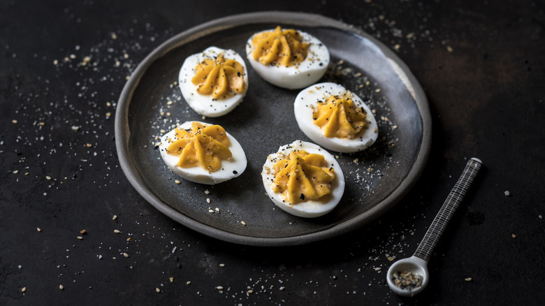 plate of five deviled eggs with seasoning