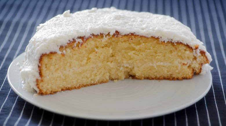 half of coconut cake sliced open on white plate