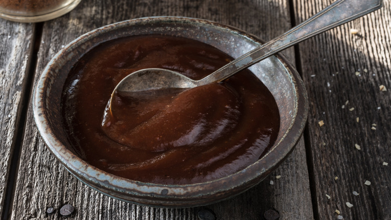 Oklahoma barbecue sauce in a small bowl with a silver spoon