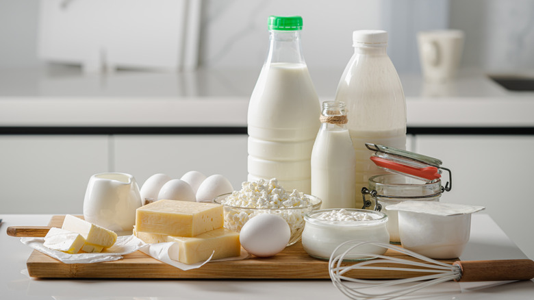 Milk, cheese, and eggs on a cutting board in a kitchen