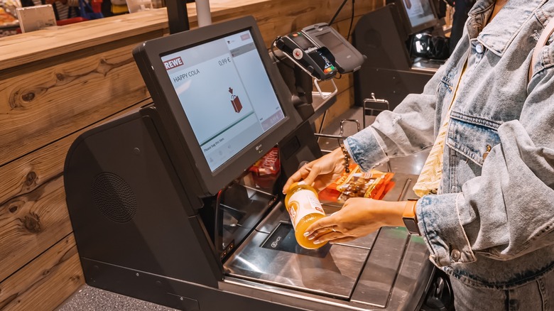 Woman scanning items at self-checkout
