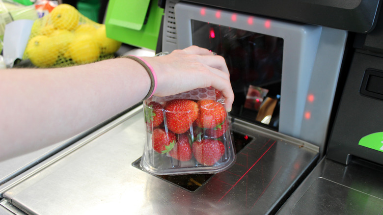 Person scanning package of strawberries