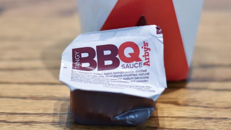 A carton of barbecue sauce on a wooden table