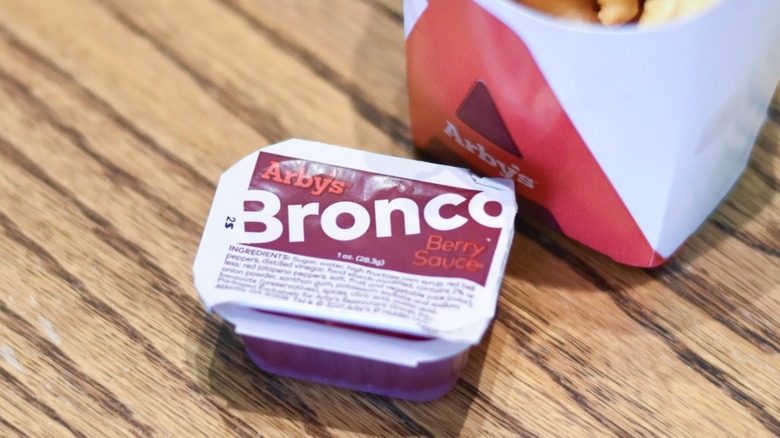 A carton of Bronco berry sauce on a wooden table