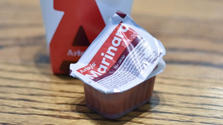 A carton of marinara sauce on a wooden table
