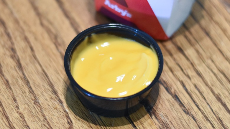 A tub of Arby's cheddar cheese sauce