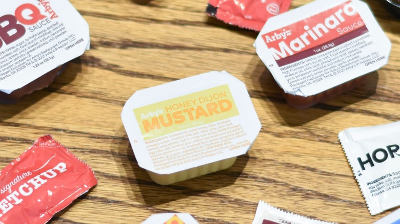 A collection of Arby's sauces on a wooden table