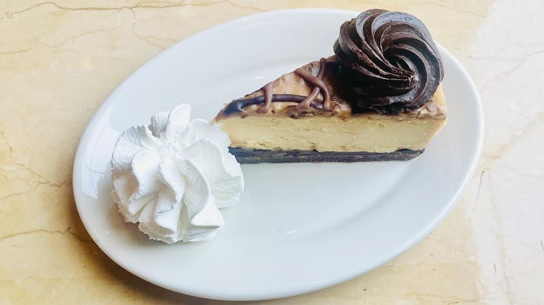 A slice of The Cheesecake Factory's Caramel Pecan Turtle Cheesecake is shown.