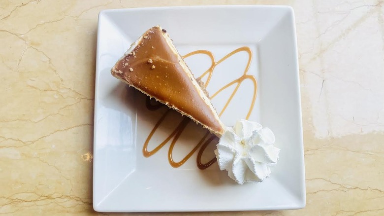 A slice of The Cheesecake Factory's Salted Caramel Cheesecake is shown.
