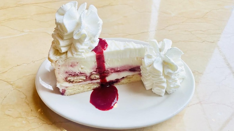 A slice of The Cheesecake Factory's Lemon Raspberry Cream Cheesecake is shown.