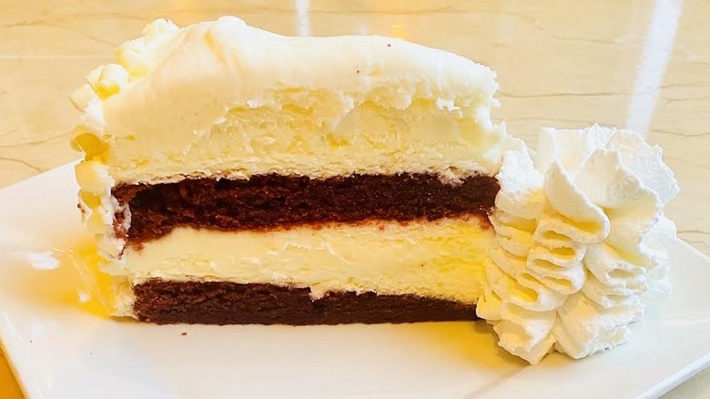 A slice of The Cheesecake Factory's Ultimate Red Velvet Cake Cheesecake is shown.