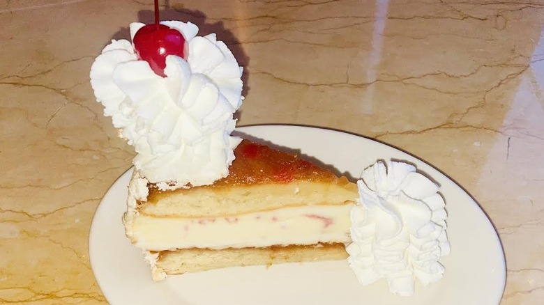 A slice of The Cheesecake Factory's Pineapple Upside-Down Cheesecake is shown.