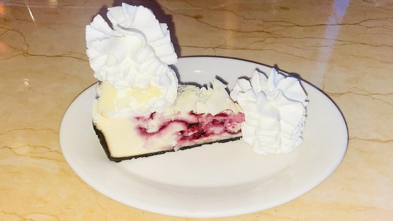 A slice of The Cheesecake Factory's White Chocolate Raspberry Truffle Cheesecake is shown.