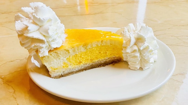A slice of The Cheesecake Factory's Mango Key Lime Cheesecake is shown.