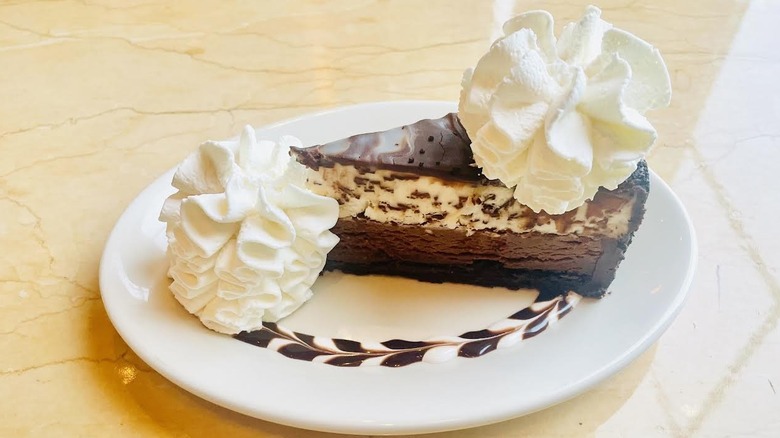 A slice of The Cheesecake Factory's Chocolate Tuxedo Cream Cheesecake is shown.