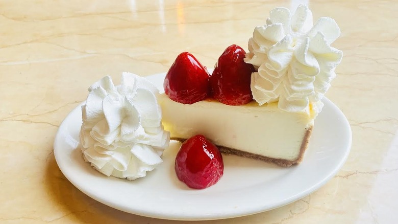 A slice of The Cheesecake Factory's Fresh Strawberry Cheesecake is shown.