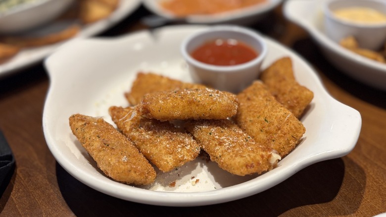 Olive Garden Fried Mozzarella with a side of sauce on dish on table