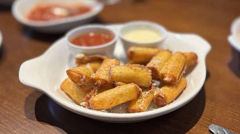 Olive Garden Stuffed Ziti Fritta on dish with dipping sauces on table