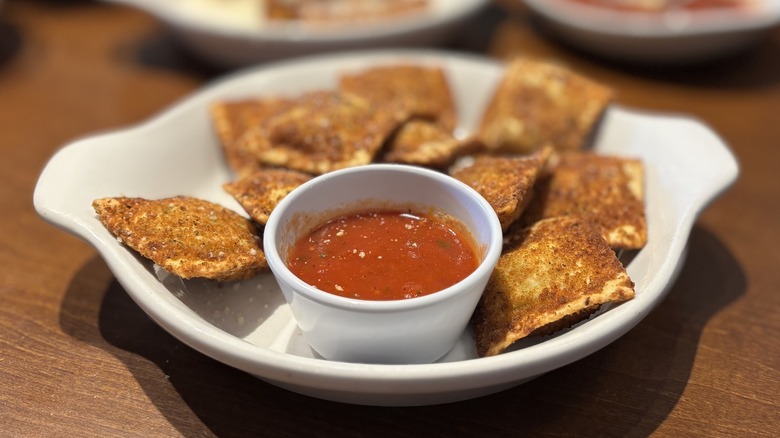 Olive Garden Toasted Ravioli with side of sauce in dish on table