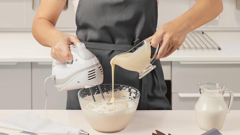 Person using hand mixer