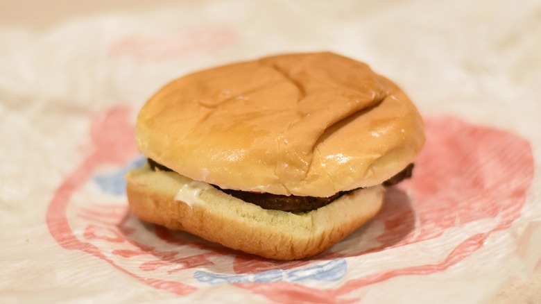 A burger with a hamburger patty and mayo on a bun