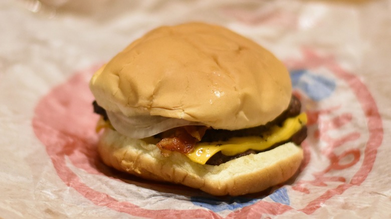 A double burger with cheese, bacon, and onion on a bun