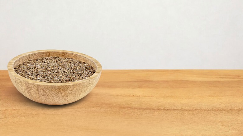 dill seeds in wooden bowl