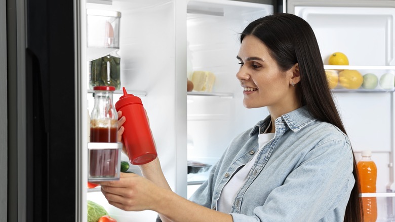 woman holding ketchup bottle