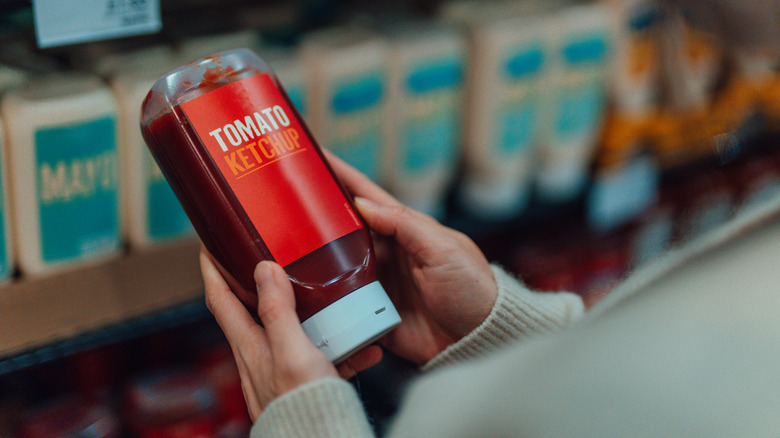 woman holding bottle of ketchup