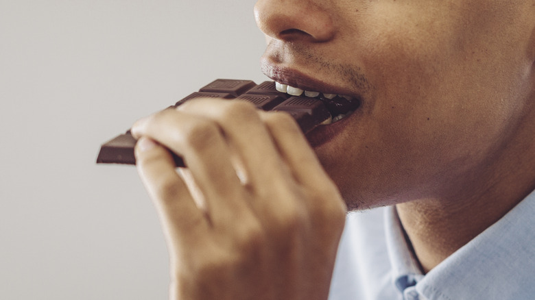 Person eating chocolate bar