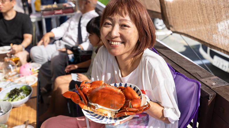 Smiling woman holding crab