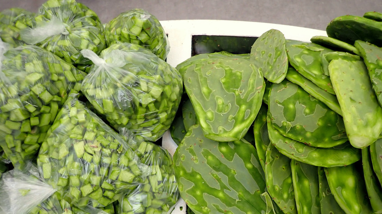 Chopped nopales in plastic bags next to whole nopales paddles