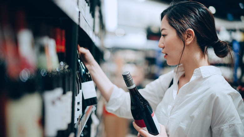 woman choosing wine at store