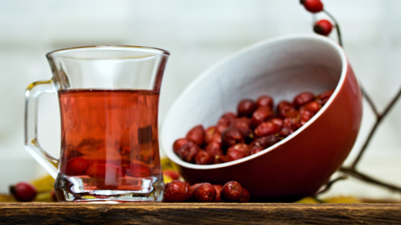 fresh rosehips and rosehip tea on counter