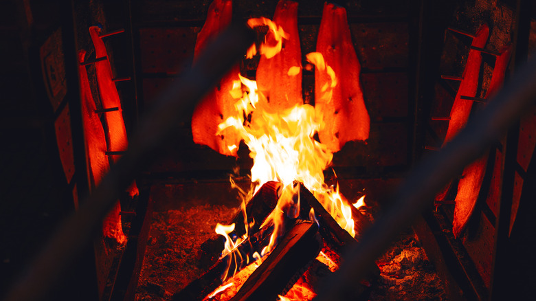 salmon fillets arranged around fire to smoke