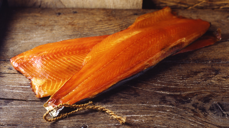 two smoked salmon fillets on wooden board