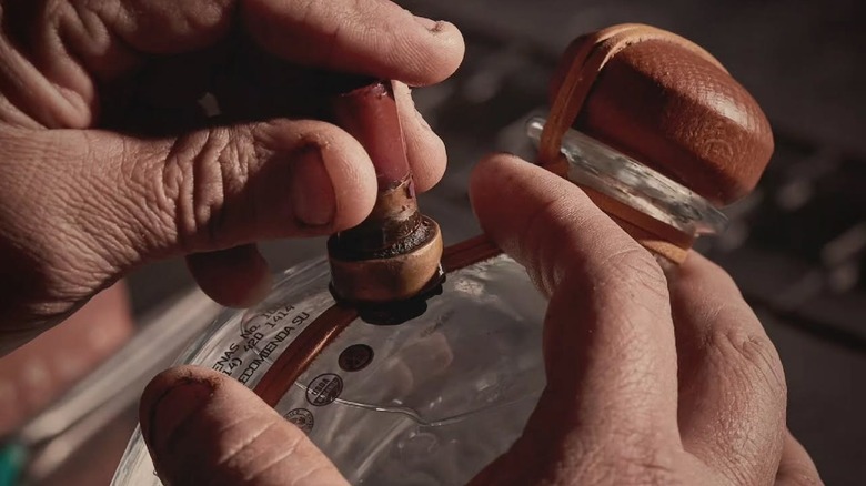 A person placing a wax stamp on a bottle of sotol