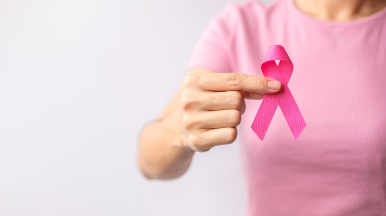 Woman holding up a pink ribbon