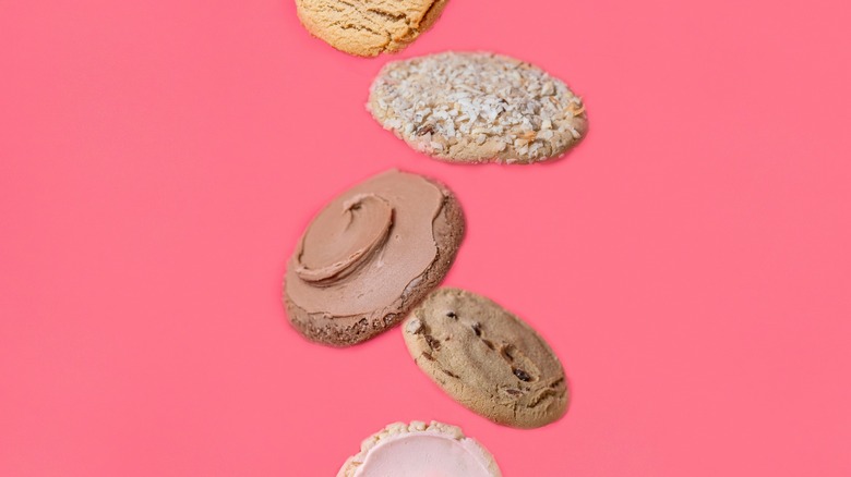 An assortment of cookies floating on a pink background