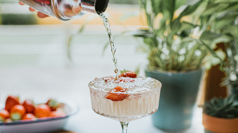 cocktail shaker pouring strawberry cocktail