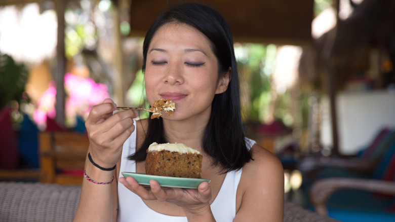 Woman savoring bite of cake