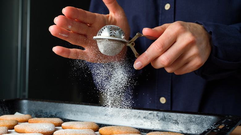 Sifting sugar onto cookies