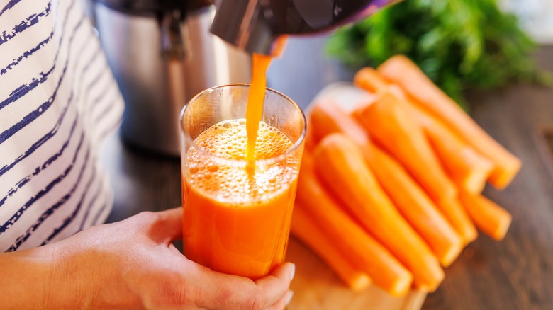 pouring fresh carrot juice