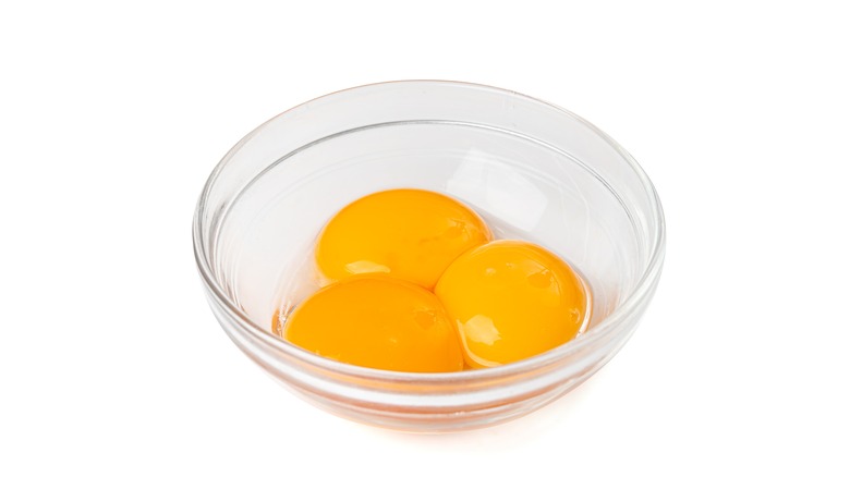 three egg yolks in bowl