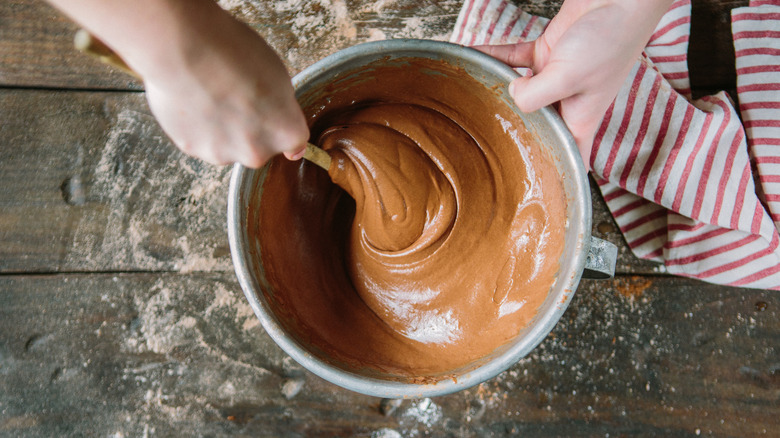 hands mixing chocolate batter