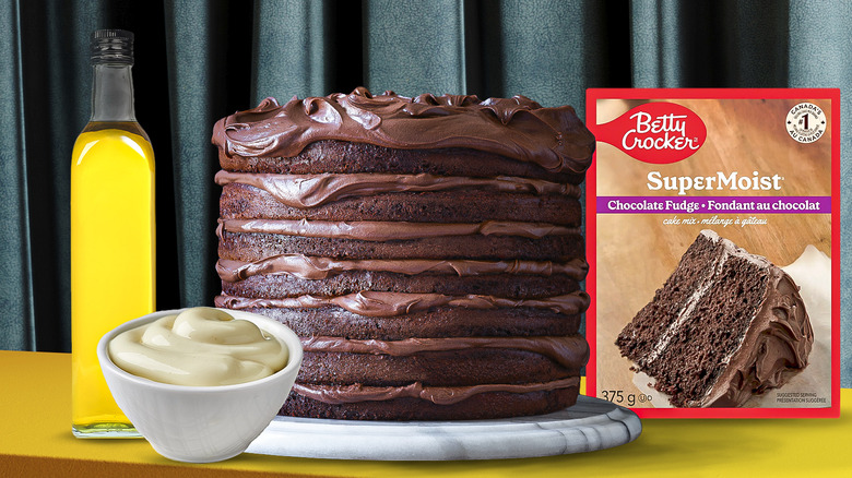 layered chocolate cake on a plate with cake ingredients surrounding it