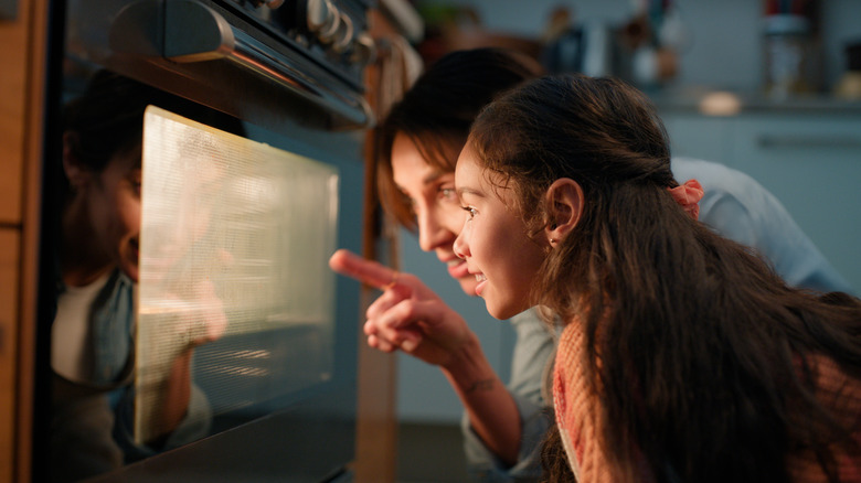 woman and child observing oven