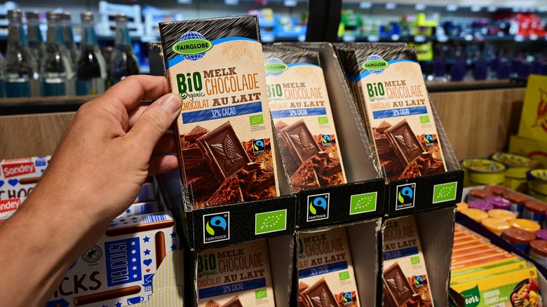 hand holding bar chocolate at store