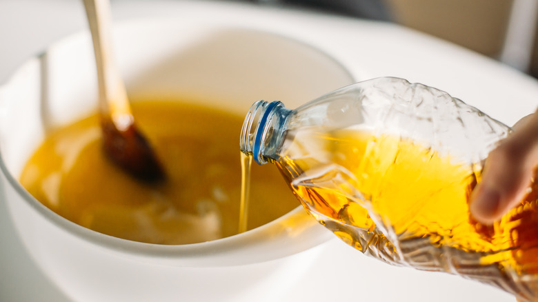 vegetable oil being poured into batter