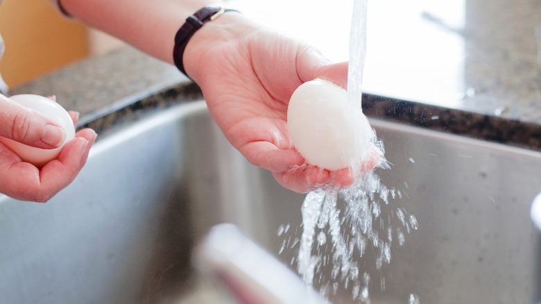 Rinsing farm-fresh eggs under warm water